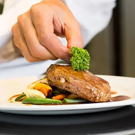 Bear Hollow Estates Chef Created Meals, chef garnishing a plate.