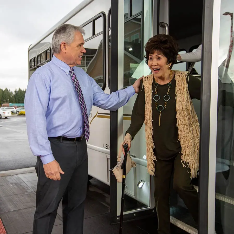 Bear Hollow Estates man helping lady off bus